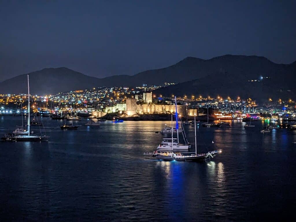 View of Bodrum castle and city lights at night from across the bay